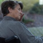 An older woman sits sadly in a wheelchair