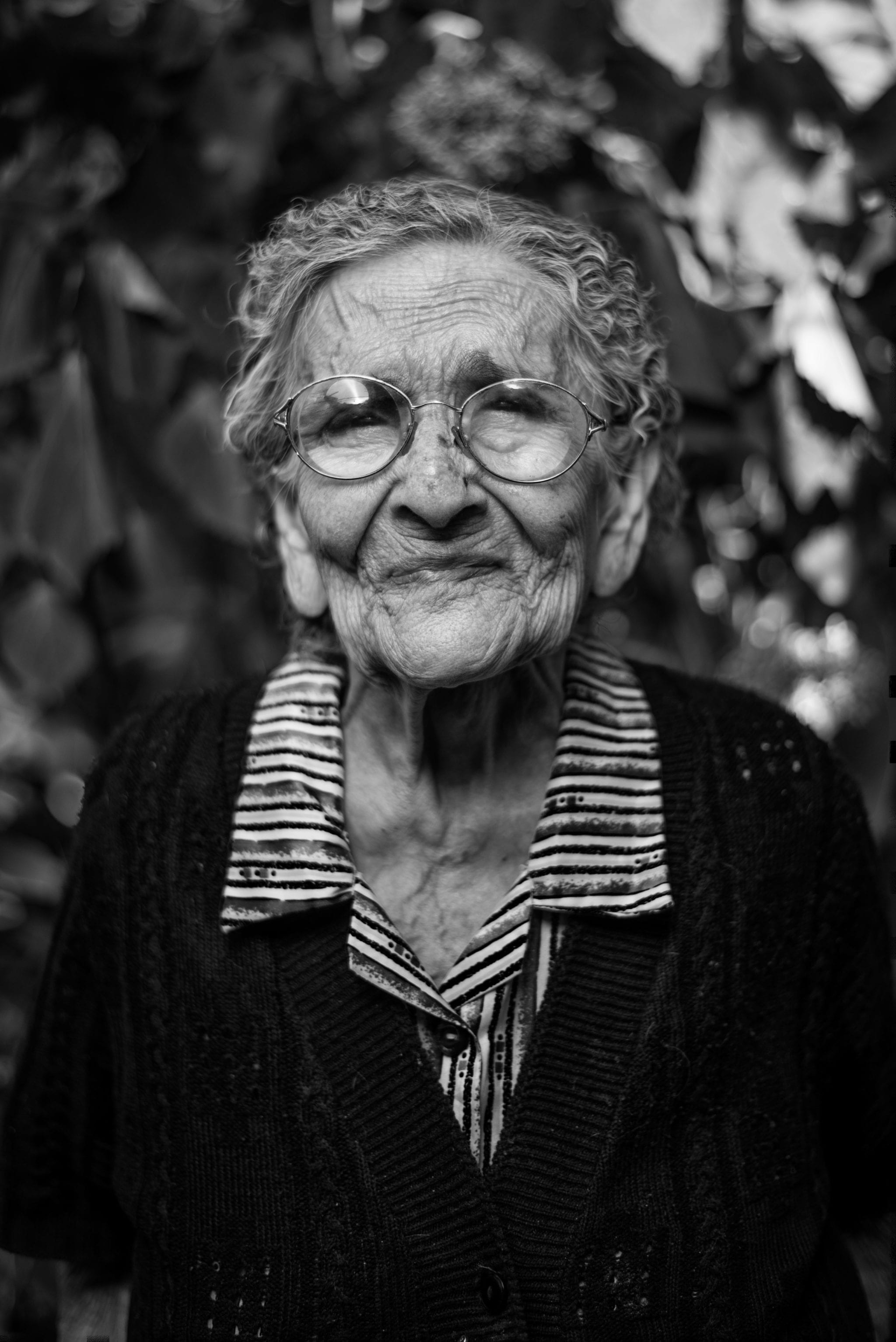 A sad elderly woman with glasses.