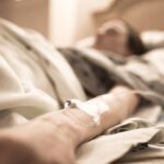 An old woman lies in a hospital bed