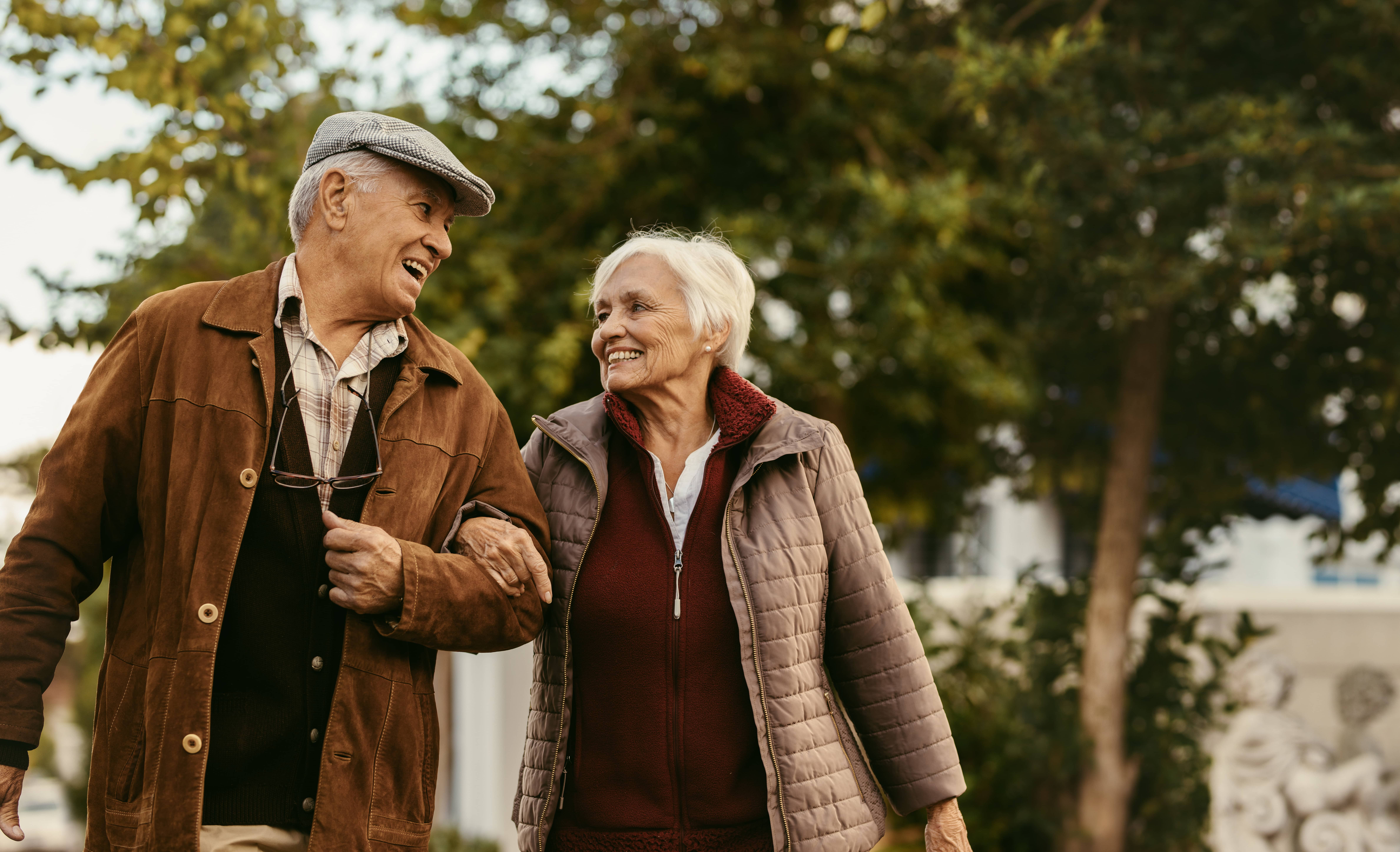 An older man and women walk outside.