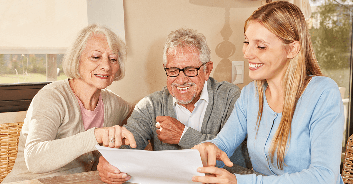 young woman sitting at table with two elderly people