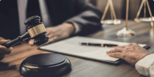 A nursing home abuse lawyer reviewing paperwork at a desk with a wooden gavel and the scales of justice.