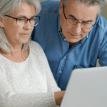 two elderly people looking at a computer