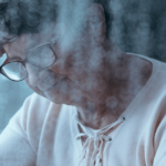 elderly woman holding her head looking sad