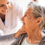 A woman helps a senior