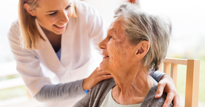A woman helps a senior