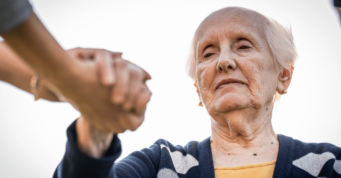 an older woman holding another person's hand