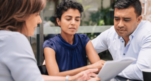 A couple consults with an attorney on nursing home negligence statute of limitations at a table outdoors.