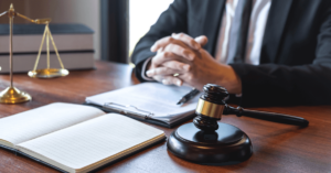 Nursing home abuse lawyer sitting at a desk next to a wooden gavel and scales of justice.