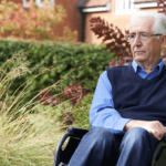 a sad older man sits in a wheelchair