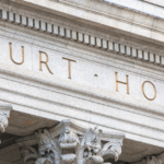 A closeup shot of a grey stone court house building.