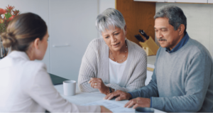 An older couple reviewing power of attorney documents at a table with their lawyer.