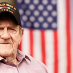 Senior veteran sits in front of flag