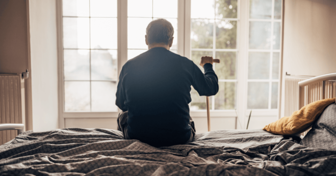 Nursing home resident alone looking out window
