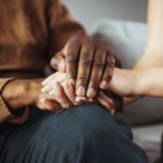 Two people holding hands in comfort