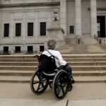 woman in wheelchair in front of court